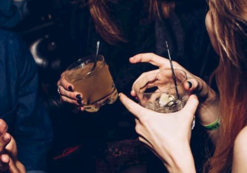 People are laughing and holding drinks in what appears to be a social gathering or party.