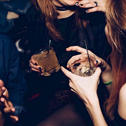 People are laughing and holding drinks in what appears to be a social gathering or party.