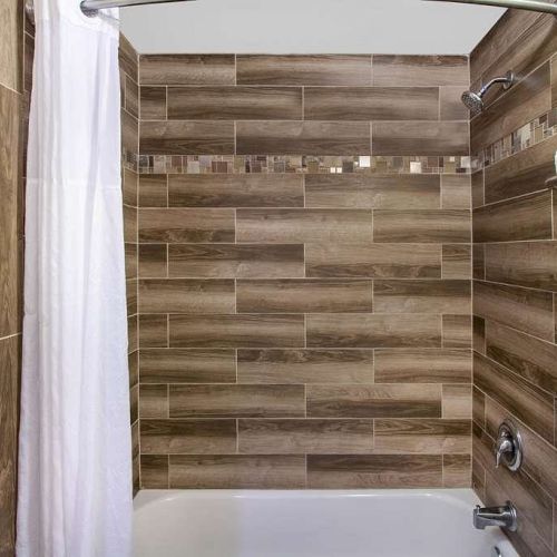 This image shows a bathroom with a tiled shower, a white curtain, and a rack holding towels mounted on the wall. The overall design is modern.